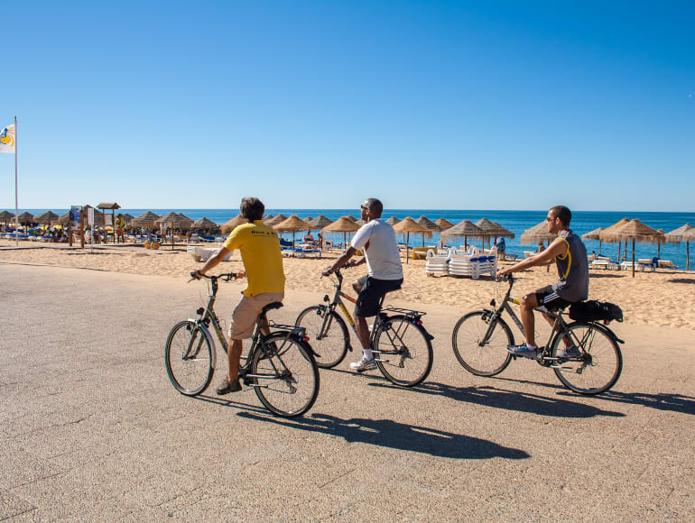 Faire du vélo sur le trottoir à côté de la plage