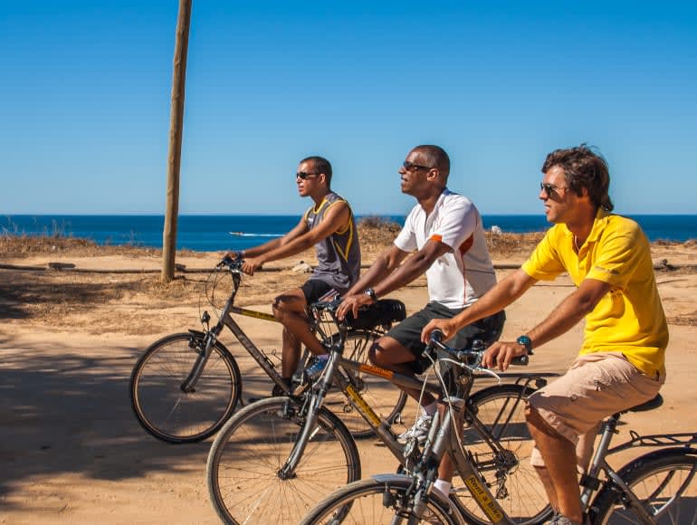 Petit groupe de cyclistes à côté de la plage
